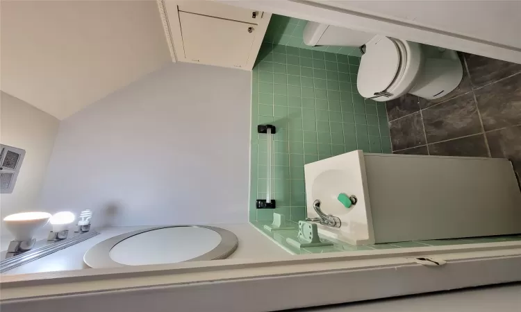 Bathroom featuring tile patterned flooring, vanity, tile walls, and toilet