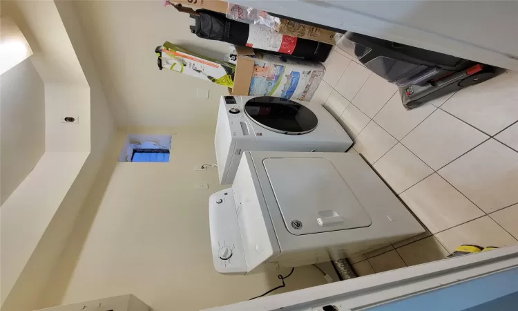 Laundry room featuring cabinets, separate washer and dryer, and light tile patterned floors