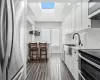 Kitchen featuring white cabinets, a tray ceiling, appliances with stainless steel finishes, and a skylight