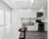 Kitchen featuring a kitchen breakfast bar, sink, white cabinets, and stainless steel appliances