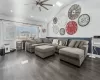 Living room with ceiling fan, dark hardwood / wood-style flooring, a wall mounted AC, and vaulted ceiling