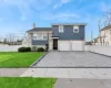 View of front facade featuring a front lawn and a garage