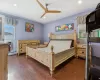 Bedroom with ceiling fan, a baseboard radiator, dark hardwood / wood-style flooring, cooling unit, and ornamental molding