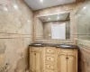 Bathroom with vanity and tile walls