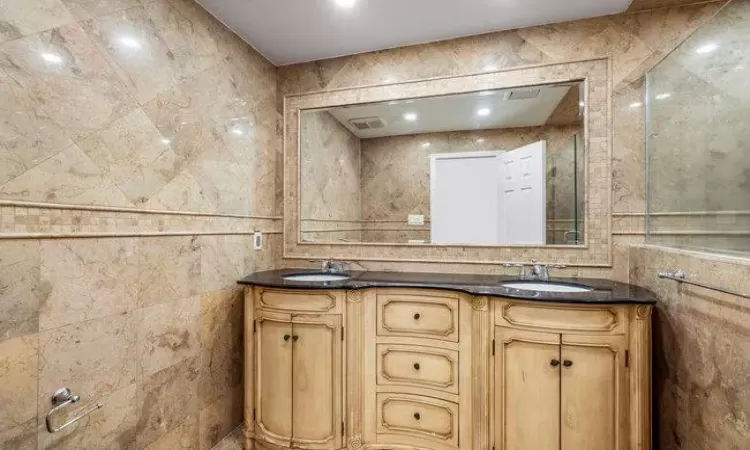 Bathroom with vanity and tile walls