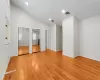 Unfurnished bedroom featuring light wood-type flooring, high vaulted ceiling, and multiple closets