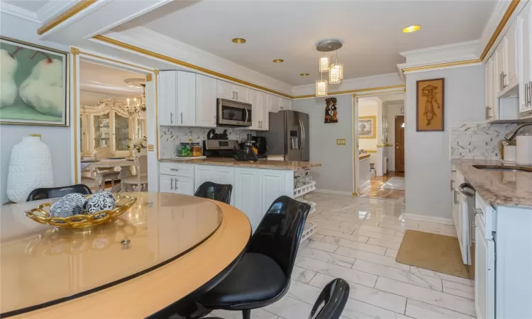 Dining area with ornamental molding, sink, and an inviting chandelier