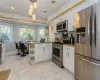 Kitchen featuring white cabinets, appliances with stainless steel finishes, and ornamental molding