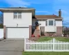 Split level home featuring a garage and a front lawn