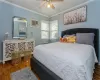 Bedroom featuring a wall mounted AC, ceiling fan, dark hardwood / wood-style floors, and ornamental molding