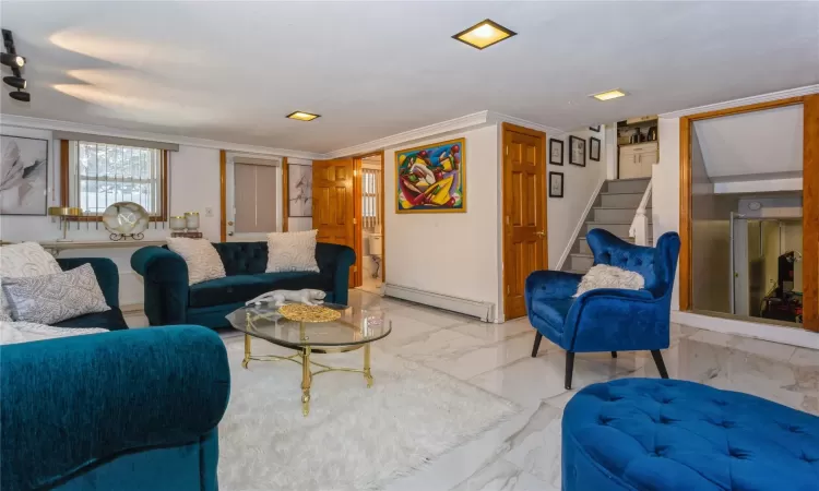 Living room featuring ornamental molding and a baseboard heating unit