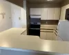 Kitchen featuring stainless steel electric stove, crown molding, exhaust hood, white fridge, and electric panel