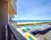 Balcony featuring a water view and a view of the beach