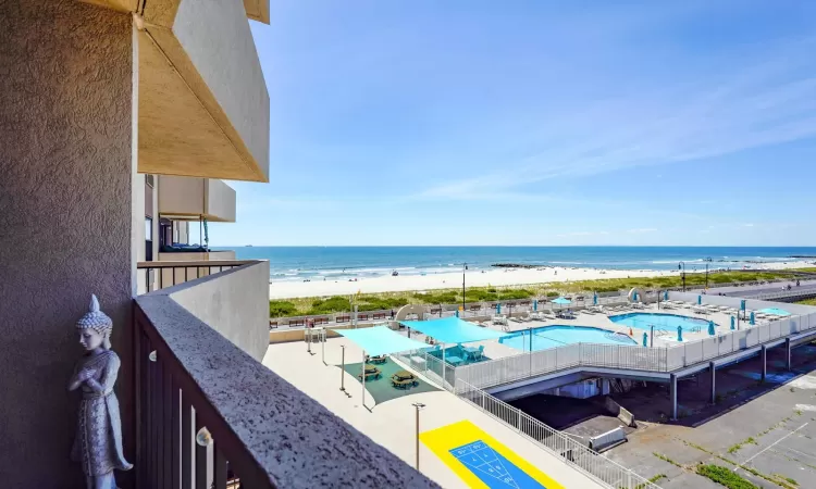 Balcony featuring a water view and a view of the beach