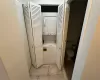 Bathroom with toilet and stacked washer/dryer