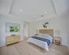 Bedroom with a tray ceiling and light hardwood / wood-style floors