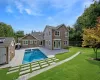 Rear view of property featuring a yard, an outbuilding, and a patio