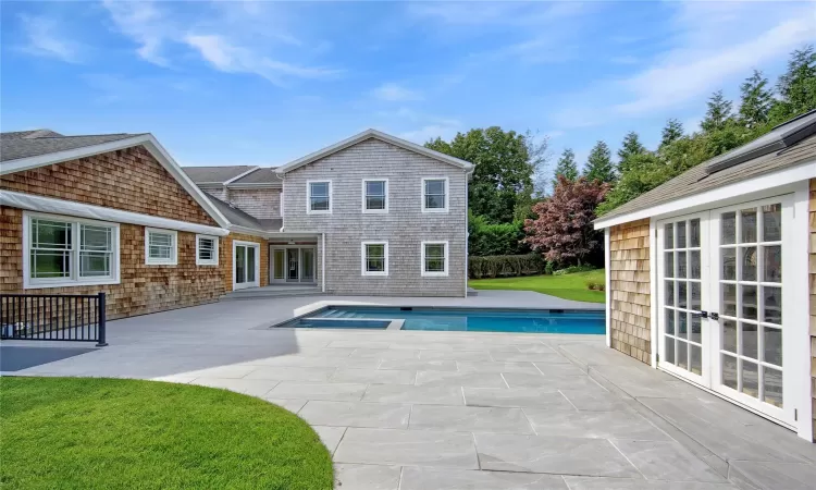 View of pool featuring a patio area, a yard, an in ground hot tub, and french doors