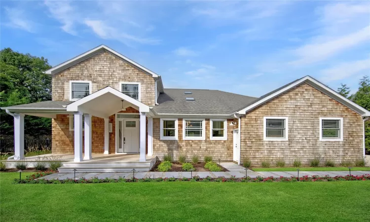 View of front of property featuring a front lawn and covered porch