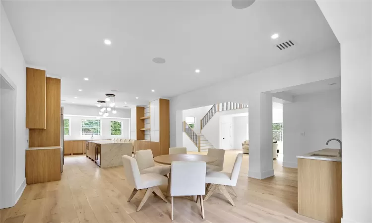 Dining space featuring light wood-type flooring, sink, and a chandelier