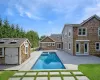 View of swimming pool with a patio and a storage shed