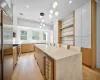 Kitchen with wine cooler, high quality appliances, a center island, white cabinetry, and hanging light fixtures