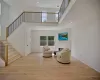 Sitting room with a high ceiling and light hardwood / wood-style flooring