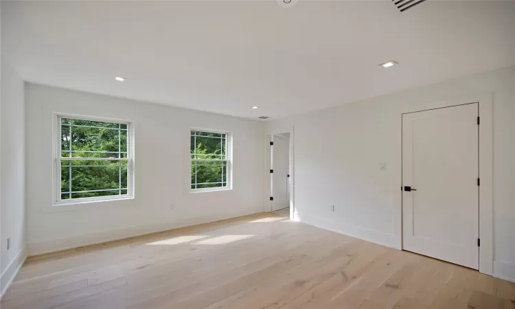 Empty room with light hardwood / wood-style floors and a wealth of natural light