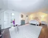 Bedroom with dark hardwood / wood-style floors, multiple windows, and a baseboard heating unit