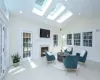 Living area with light tile patterned floors, high vaulted ceiling, and a healthy amount of sunlight