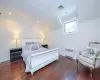 Bedroom featuring vaulted ceiling, radiator heating unit, and dark hardwood / wood-style floors