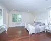 Bedroom featuring vaulted ceiling, radiator, dark hardwood / wood-style floors, and multiple windows