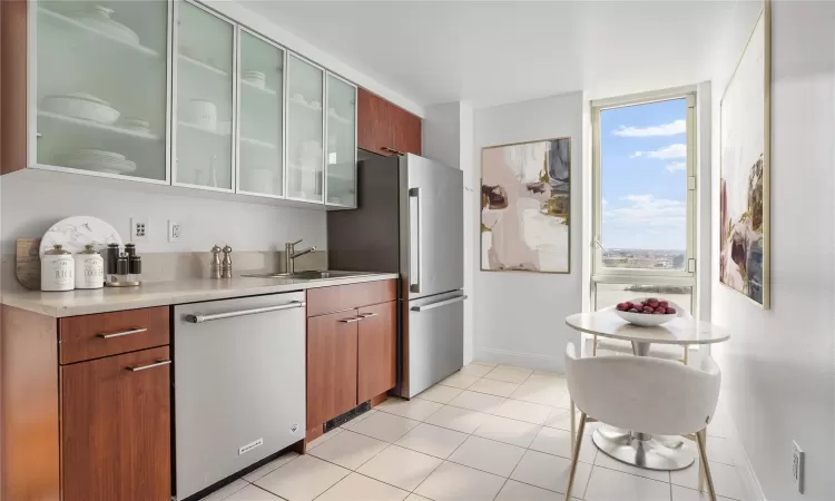 Kitchen with appliances with stainless steel finishes, light tile patterned floors, and sink