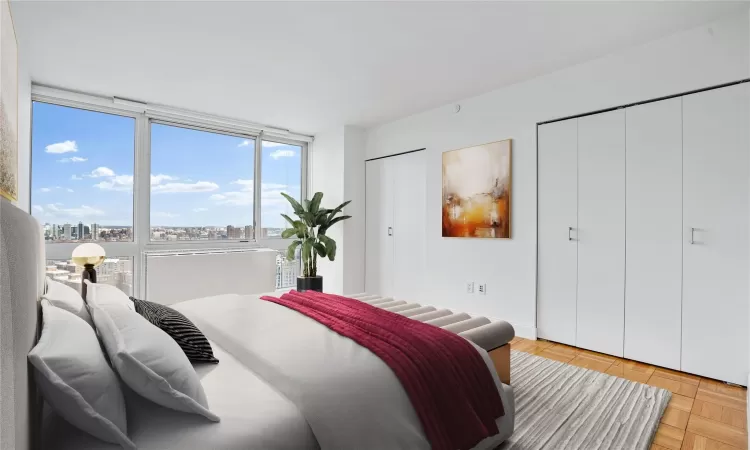 Bedroom featuring floor to ceiling windows and two closets