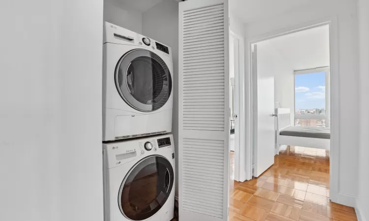 Clothes washing area featuring stacked washer and dryer