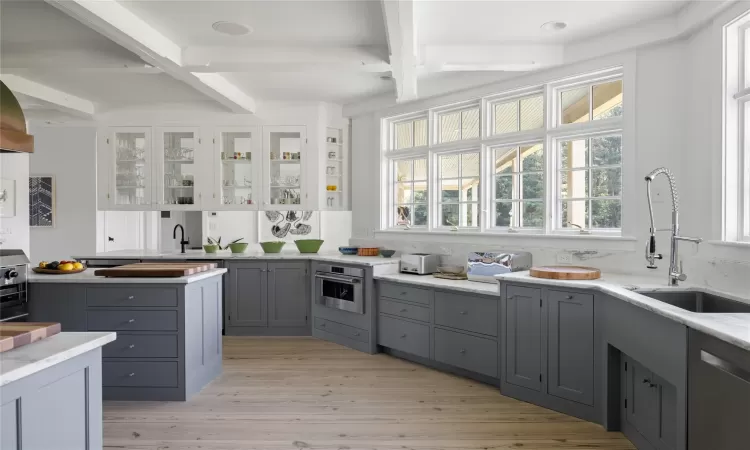 Kitchen featuring gray cabinetry, sink, light hardwood / wood-style floors, white cabinetry, and stainless steel appliances