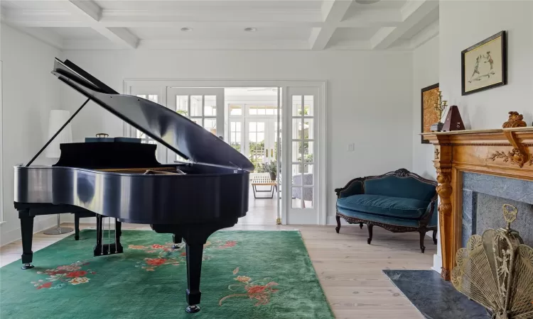 Sitting room featuring beamed ceiling, french doors, light hardwood / wood-style floors, and coffered ceiling