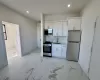 Kitchen featuring white cabinets, decorative backsplash, sink, and appliances with stainless steel finishes