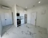 Kitchen featuring an AC wall unit, white cabinetry, sink, and stainless steel appliances