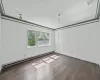 Empty room featuring dark hardwood / wood-style flooring and a baseboard radiator