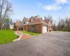 View of front of house featuring a garage, central air condition unit, and a front lawn