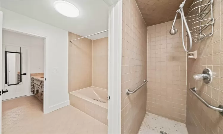 Bathroom with tile patterned floors, vanity, and shower with separate bathtub