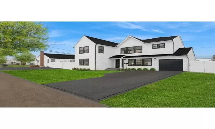 View of front of house with a garage and a front lawn