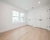 Bedroom with light hardwood floors and multiple closets