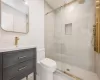 Bathroom with vanity, toilet, and a shower with shower door