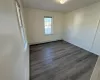 Unfurnished room featuring dark wood-type flooring and a baseboard radiator