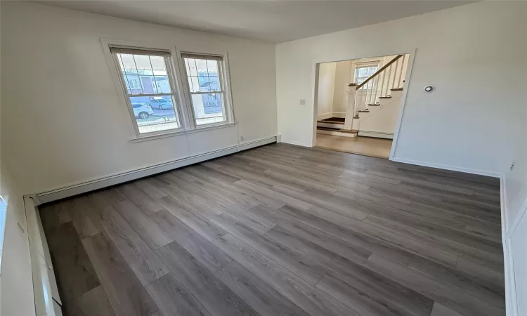 Unfurnished room with hardwood / wood-style floors and a baseboard radiator