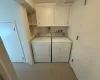 Laundry room featuring separate washer and dryer and cabinets