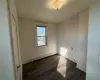 Unfurnished room featuring dark hardwood / wood-style floors, baseboard heating, and crown molding