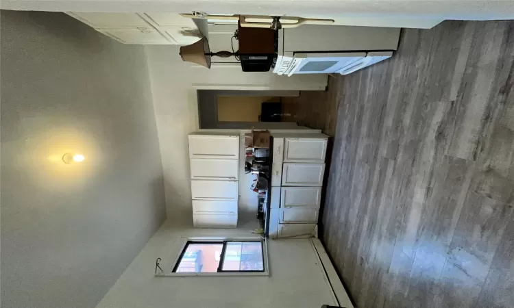 Kitchen featuring white cabinets, light hardwood / wood-style flooring, fridge, and a baseboard heating unit